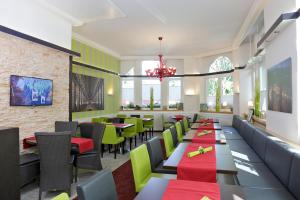 弗莱堡波斯特公园酒店的餐厅设有绿色和红色的桌椅