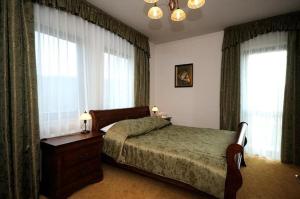 Hoczew蝾螈酒店的一间卧室配有一张床、梳妆台和窗户。