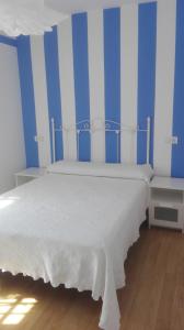 阿维拉VuT Dalia 4的卧室配有白色的蓝色和白色条纹床