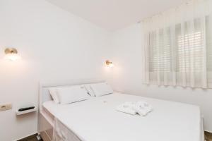 科托尔Apartments Los Olivos的白色的卧室设有床和窗户