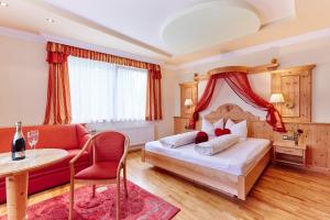 滨湖伦茨Landhotel Zellerhof的一间卧室配有一张床、一张桌子和一张沙发