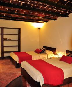 拉巴斯Hotel Naira的酒店客房,配有两张带红色床单的床