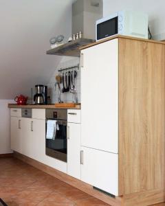 Sabrodt羊驼度假公寓的厨房配有白色橱柜和微波炉