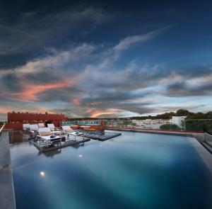 埃武拉维多利亚之石酒店的享有带屋顶椅子的游泳池的景色