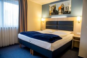 美因河畔法兰克福罗德赫梅尔水塔酒店的酒店客房的床铺上铺有蓝色毯子