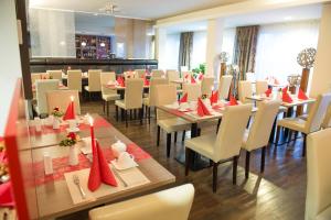 美因河畔法兰克福罗德赫梅尔水塔酒店的用餐室配有桌椅和红色餐巾