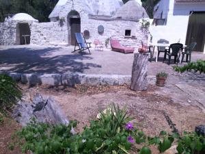 弗兰卡维拉丰塔纳Vacanza in casa rurale nel Salento的后院设有石屋,配有桌椅