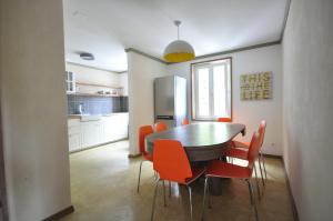 MattenJungfrau Family Holiday Home的厨房配有餐桌和橙色椅子