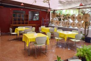 科托努Hotel Saint-Jean的用餐室配有黄色的桌椅