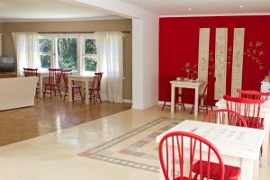 坦迪尔Hosteria Mi Casa en la Sierra的一间用餐室,配有红色的墙壁和红色的椅子