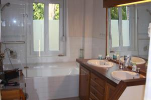 亚眠乐齐奥斯克亚眠住宿加早餐旅馆的浴室配有两个盥洗盆和浴缸。