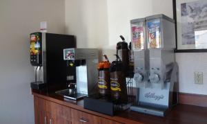科罗拉多斯普林斯速8科罗拉多斯普林斯机场酒店的一个带咖啡壶和几瓶酒的柜台