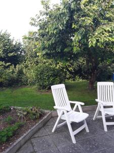 基希海姆Ferienwohnung Mayer的花园庭院里两把白色椅子