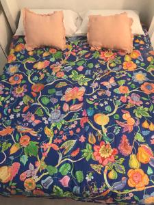 厄尔梅达诺Las Olas的一张带花卉床罩和两个枕头的床