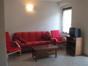 Tiarno di SottoCasa Anita的客厅配有红色沙发和2把红色椅子