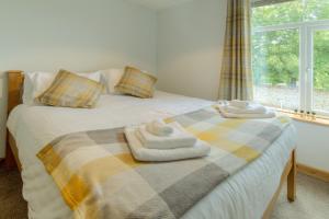 滨海凯斯特Beach Breeze Cottage - 3 Bed的一间卧室配有带毛巾的床