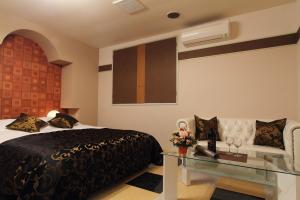 铫子市Restay Choshi Ragna (Adult Only)的一间卧室配有一张床和一张玻璃桌