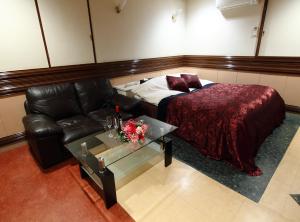 铫子市相根再住旅馆（仅限成人）的客房设有床、沙发和桌子。