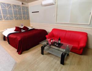 铫子市相根再住旅馆（仅限成人）的一间卧室配有红色的床和红色的沙发