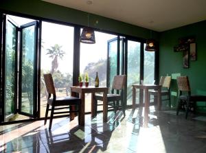 西归浦市泰国故事度假屋的用餐室配有桌椅和大窗户