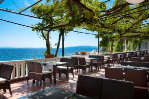 奥帕提亚Hotel Kristal - Liburnia的一间设有桌椅的海洋餐厅
