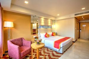 维沙卡帕特南海豚酒店的配有一张床和一把椅子的酒店客房