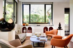 罗马普利策酒店的客厅配有橙色椅子和桌子