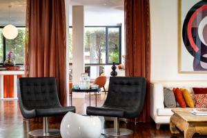 罗马普利策酒店的带沙发的客厅配有两把黑色椅子