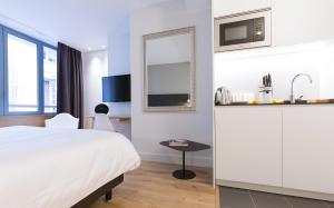 波尔多Studio luxe hyper centre piscine的酒店客房配有床、桌子和镜子