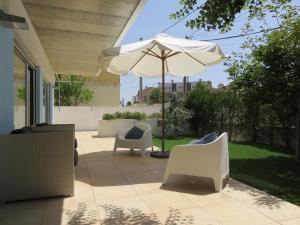 沙尔内卡Casa azul的庭院配有两把椅子和一把遮阳伞
