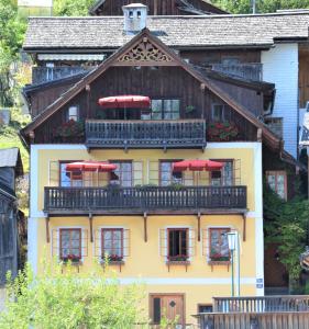 哈尔施塔特弗兰齐斯卡之家公寓的房屋设有带红色遮阳伞的阳台