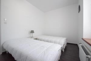 迪纳尔Appartement a dinard的白色墙壁客房的两张床