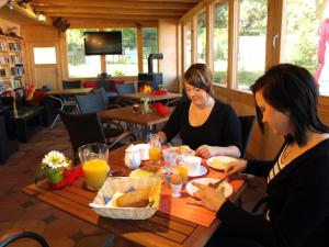 施滕贝格Ferienhaus am Luckower See的两个坐在餐桌上吃食物的女人