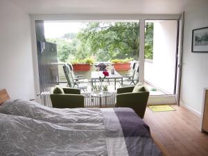 圣安德里斯伯格Apartment Harzgrün的一间卧室配有一张床,阳台配有桌椅
