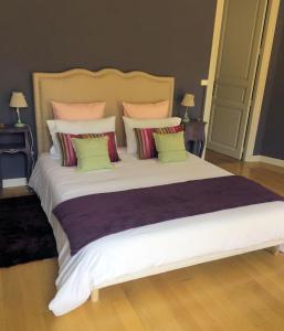 马扎梅GUESTHOUSE La VILLAE的卧室配有一张带彩色枕头的大型白色床。