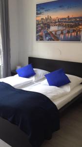 美因河畔法兰克福Main Hotel Frankfurt City的一间卧室配有两张带蓝色枕头的床