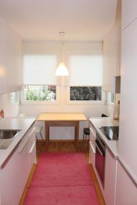 拉萨Haus Ilse & Karl Heinz的厨房配有桌子和红色地毯