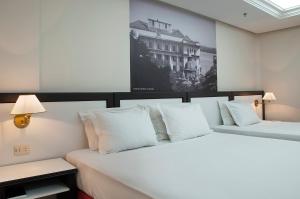 阿雷格里港Master Grande Hotel - Centro Histórico的客房内的两张床和白色枕头