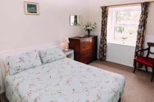 KilryIncheoch Farm Cottage的一间卧室配有一张床、一个梳妆台和一扇窗户。