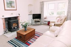 KilryIncheoch Farm Cottage的客厅配有白色沙发和壁炉