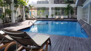吉隆坡吉隆坡美利亚酒店的一个带椅子和桌子的大型游泳池