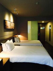 上海锦江之星品尚上海国际旅游度假区川沙地铁站酒店的酒店客房,配有两张带白色床单的床