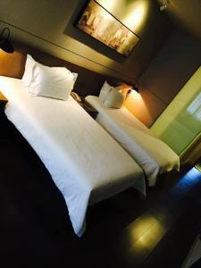 上海锦江之星品尚上海国际旅游度假区川沙地铁站酒店的配有2张床铺的酒店客房,提供白色床单和枕头