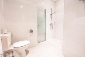 特拉维夫Central Laguardia Hotel的白色的浴室设有卫生间和淋浴。