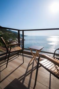 北竿马祖北竿舒漫活海景旅宿 的阳台配有两把椅子和一张桌子,享有海景。