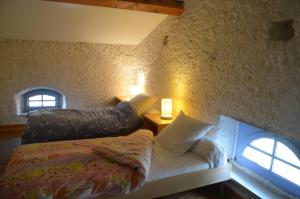 Auriac-sur-Vendinelle奥坦玫瑰度假屋的一间卧室配有一张床、一张沙发和两个窗户。
