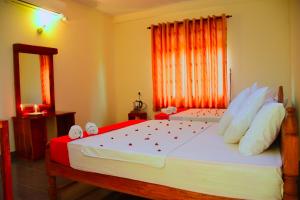 波隆纳鲁沃山景酒店的一间卧室配有一张大床和镜子