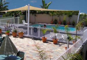 梅林布拉水景豪华公寓的一座带白色围栏和植物的游泳池