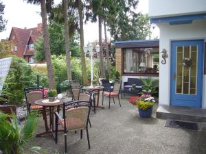 蒂门多弗施特兰德克拉拉公寓式酒店的一个带桌椅的庭院和一扇蓝色的门