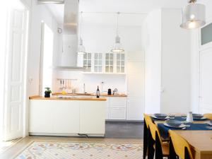 瓦伦西亚City Hall Correos的厨房配有白色橱柜和桌椅